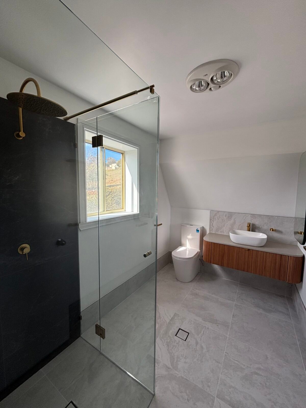 Completed bathroom with frameless glass shower, timber vanity and grey floor tiles