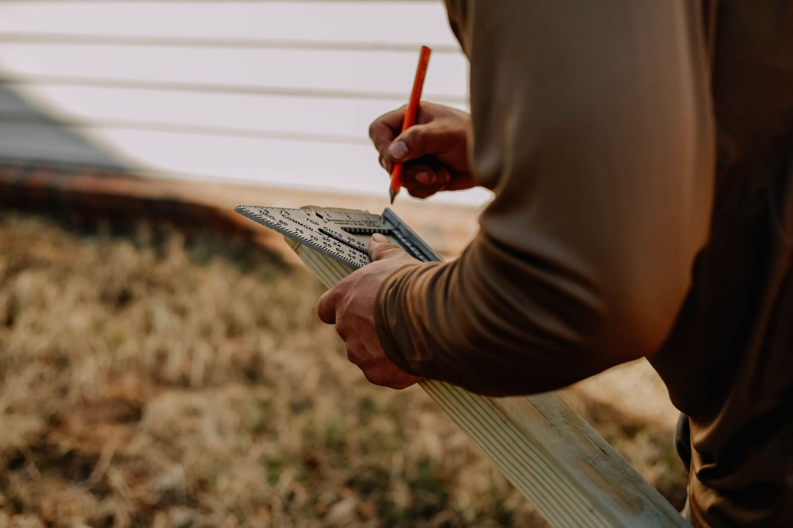 Worker measuring timber outdoors